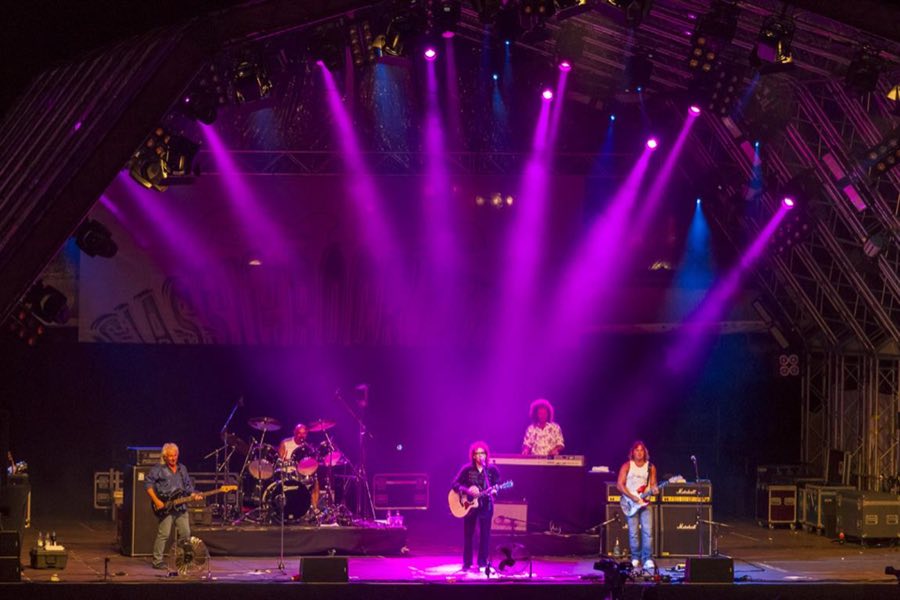 Band auf einer Bühne in magentafarbenem Licht